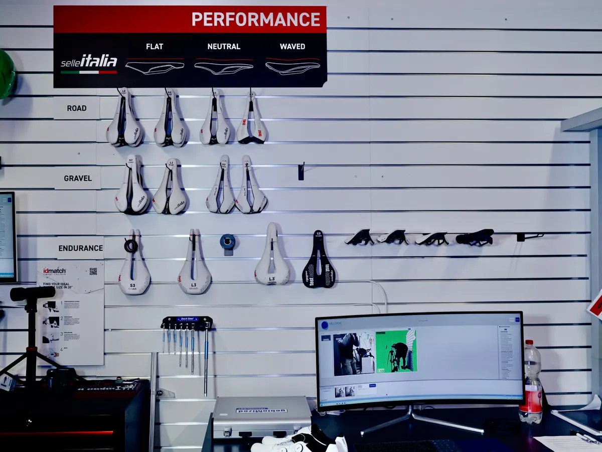 Sattelwand mit Testsätteln und Analyse-Bildschirm im Sportster24-Bike-Fitting-Studio