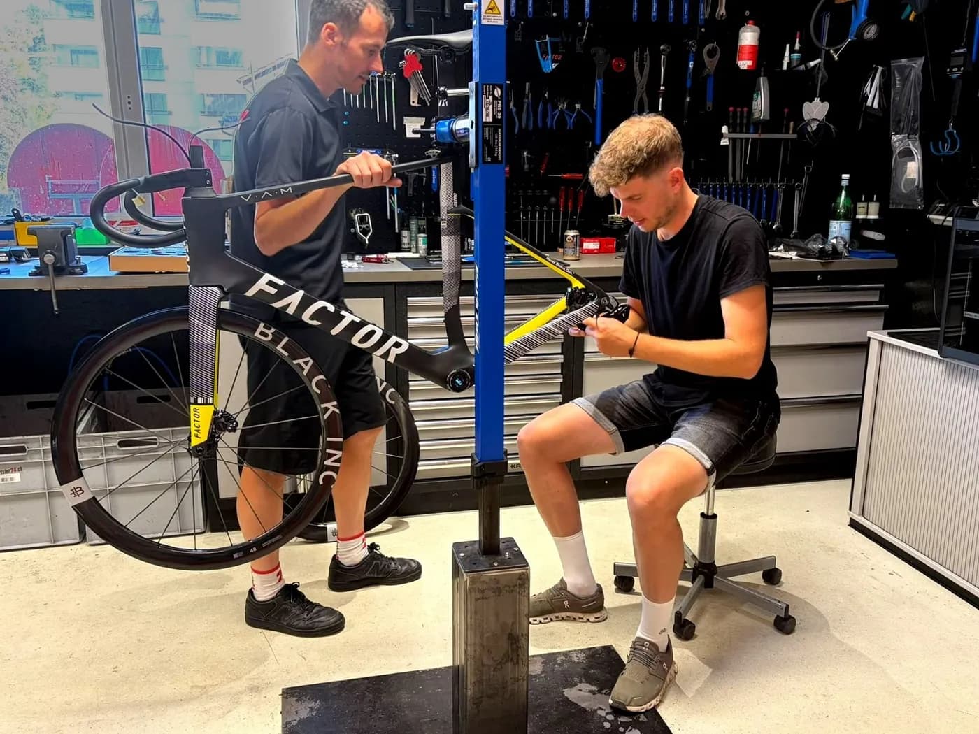 Kunde baut sein Factor-Velo zusammen mit einem Sportster24-Mechaniker in der Werkstatt auf
